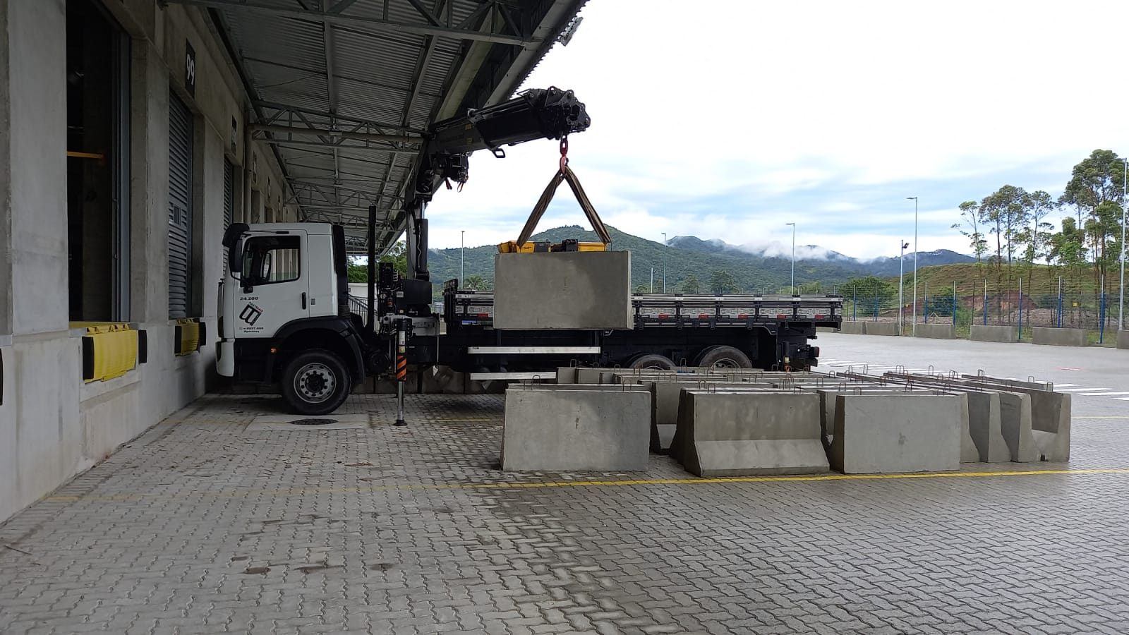 Munck içando bloco de concreto em pátio industrial