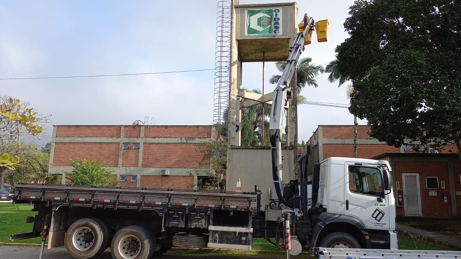 Munck içando caixa d'água até o alto da torre