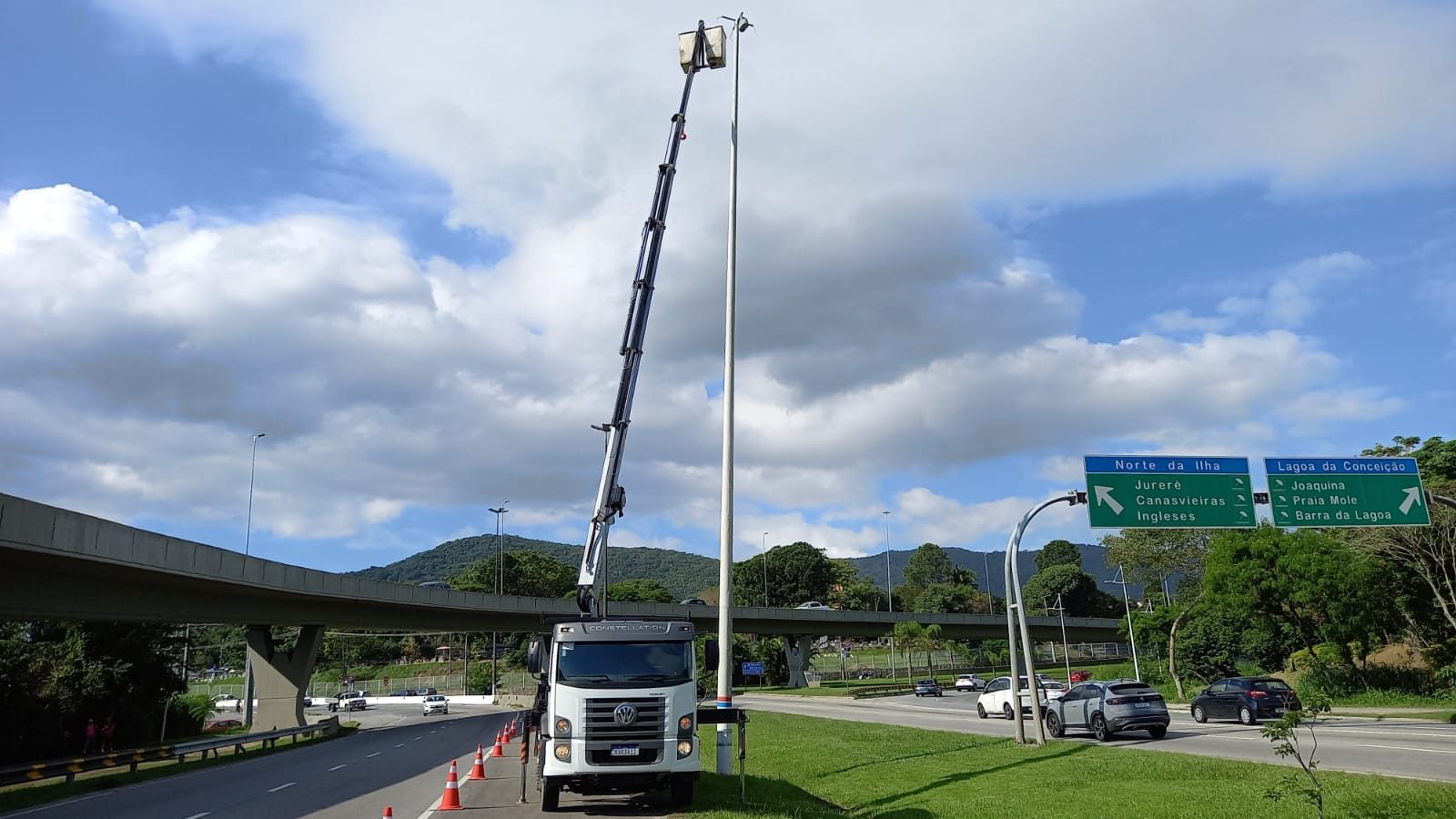 Cesto aéreo em poste de iluminação à beira da rodovia