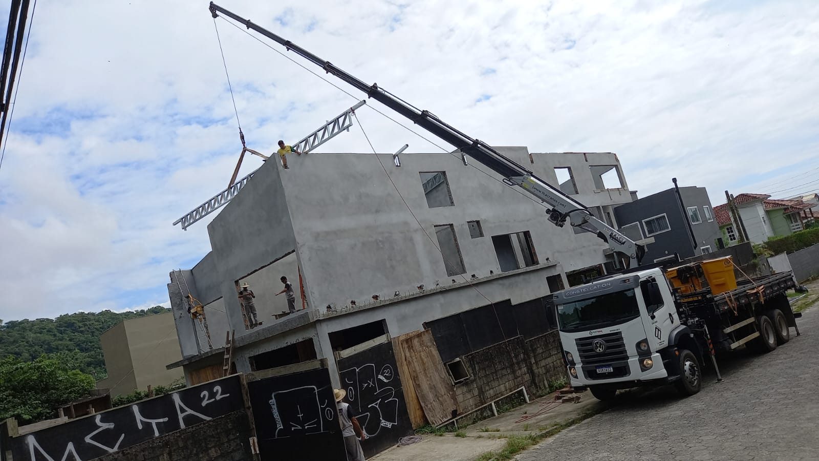 Munck içando estrutura metálica sobre sobrado em obra